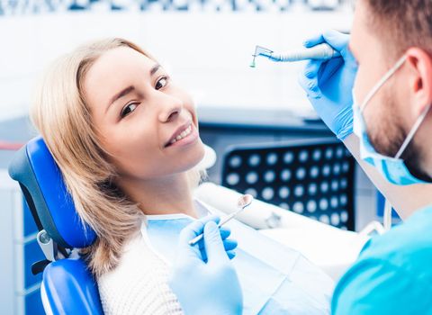 Dentist treating blond smiling girl