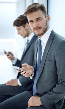 close up. two business men sitting in the office waiting room.people and technology