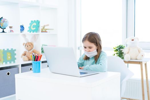 Cute little girl studying at home during quarantine