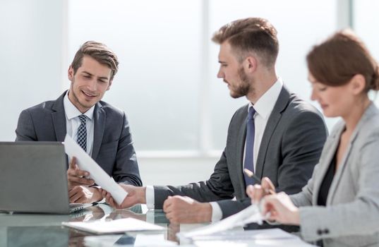 employees discuss business documents sitting at the Desk.the concept of teamwork