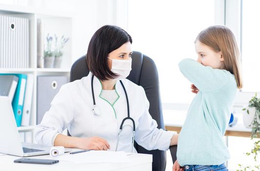Examination of little girl by doctor in modern clinic