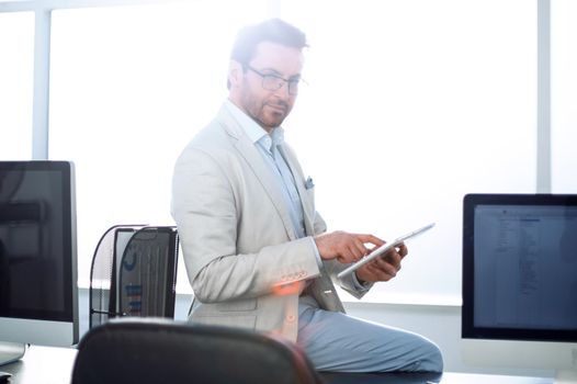 attentive businessman uses a digital tablet in a modern office.people and technology