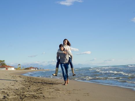 Men Giving Piggy Back Rides At Sunset By The Sea, autumn time