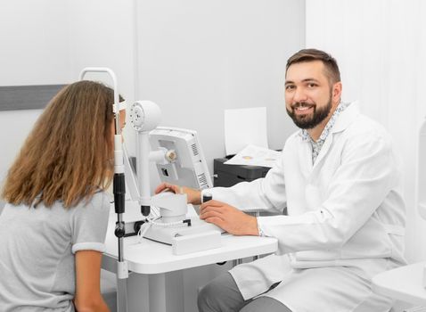 doctor examines a girl eyesight in a modern clinic