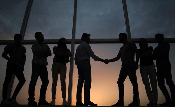 in full growth.handshake of business partners on the background of the office window