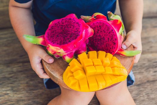 Diced dragon fruit and mango in the hands of the boy.