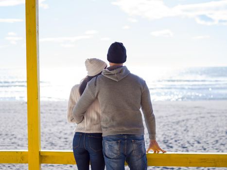 Happy couple enyojing time together on beach during autumn day