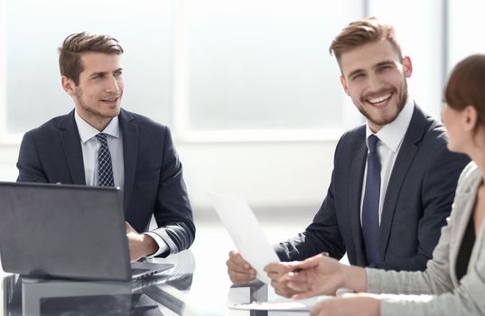 business team discusses sitting at their Desk.the concept of teamwork