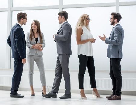 in full growth.a group of business people talking in the lobby of the office.photo with copy space
