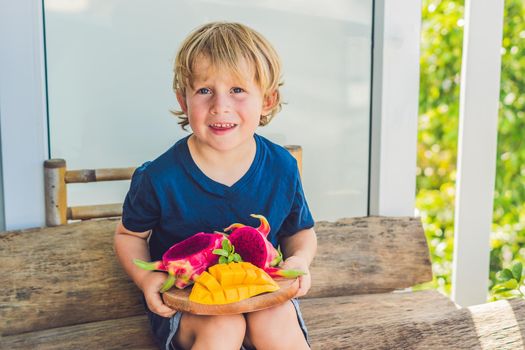 Diced dragon fruit and mango in the hands of the boy.