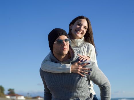 Men Giving Piggy Back Rides At Sunset By The Sea, autumn time