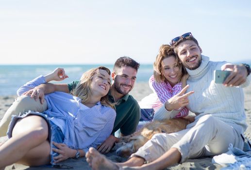 Group Of Young Friends Spending The Day On A Beach during autumn day