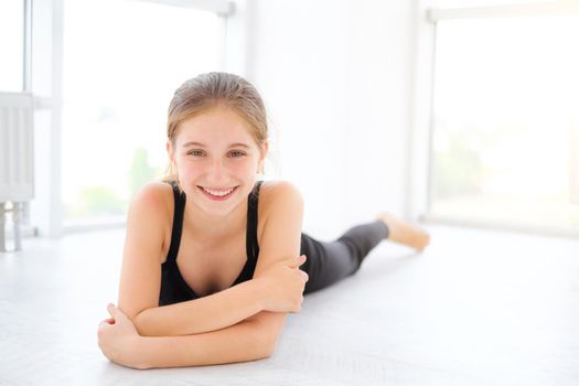 Cute teenager girl lying on a floor in light room