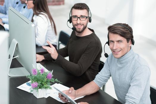 employees of the business center with a headset in the workplace.people and technology