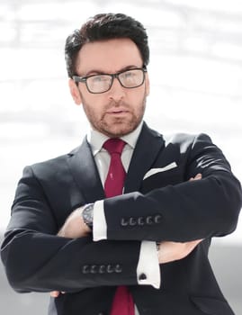 portrait of a confident businessman with glasses on the background of the office