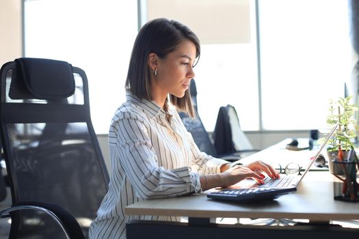 Portrait of a happy businesswoman sitting at her workplace in office