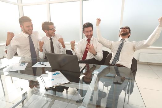 very happy business team sitting at the Desk.the concept of a successful startup