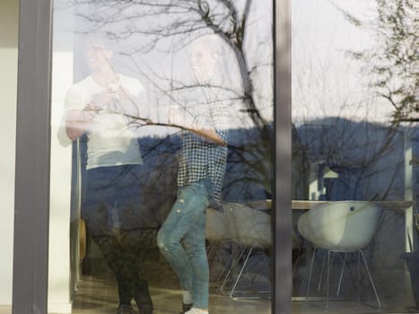 romantic happy young couple enjoying morning coffee by the window in their luxury home