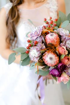 Close up pink bouquet of flowers in bride hands. Concept of floristic art and bridal photo session.
