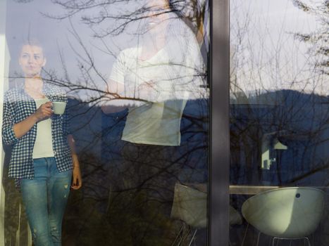 romantic happy young couple enjoying morning coffee by the window in their luxury home