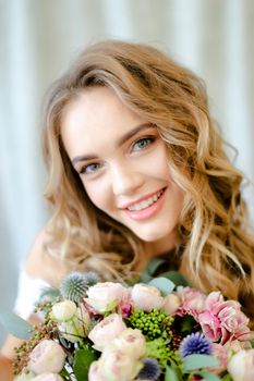 Close up portrait of young nice bride with bouquet at studio. Concept of bridal photo session and floristic art.