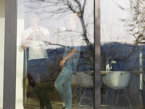 romantic happy young couple enjoying morning coffee by the window in their luxury home