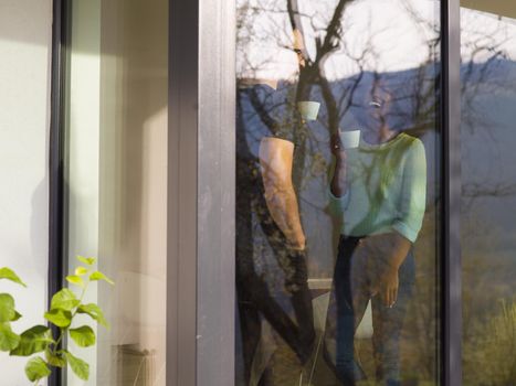 romantic happy young multiethnic couple enjoying morning coffee by the window in their luxury home