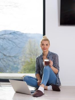 Real Woman Using laptop At Home on the floor Drinking Coffee Enjoying Relaxing