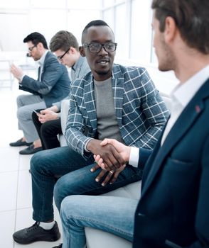 handshake of business people sitting in the office lobby.business concept