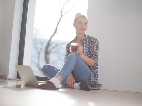 Real Woman Using laptop At Home on the floor Drinking Coffee Enjoying Relaxing