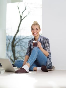 Real Woman Using laptop At Home on the floor Drinking Coffee Enjoying Relaxing