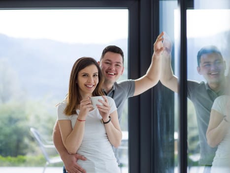 romantic happy young couple enjoying morning coffee by the window in their luxury home