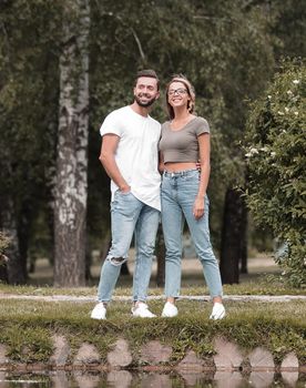 couple in love standing on the grass near the lake .romance and love