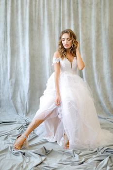 Young caucasian bride standing at studio. Concept of wedding and bridal photo sesion, fashion, nice fiancee.