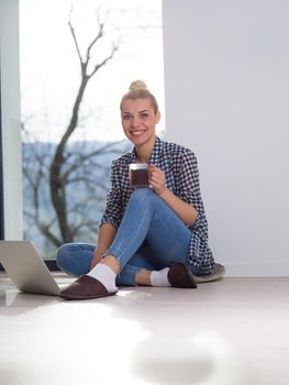 Real Woman Using laptop At Home on the floor Drinking Coffee Enjoying Relaxing