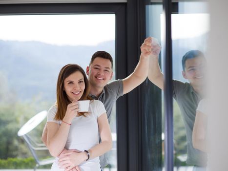 romantic happy young couple enjoying morning coffee by the window in their luxury home