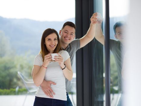 romantic happy young couple enjoying morning coffee by the window in their luxury home