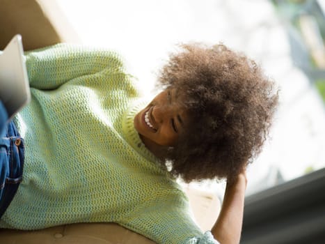 Young african american woman at home relaxing in her luxury lliving room reading a digital tablet  surf internet and work