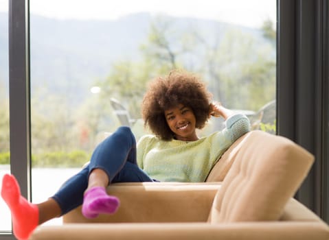 Young african american woman at home relaxing in her luxury lliving room reading a digital tablet  surf internet and work