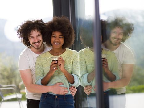 romantic happy young multiethnic couple enjoying morning coffee by the window in their luxury home