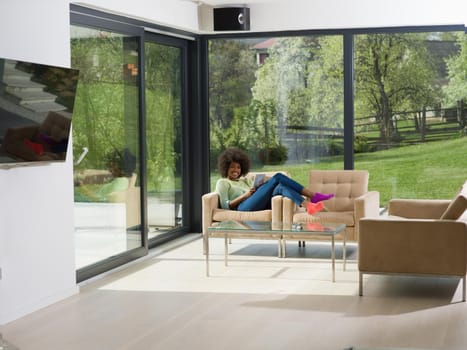 Young african american woman at home relaxing in her luxury lliving room reading a digital tablet  surf internet and work