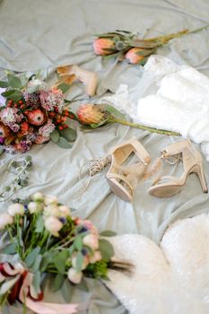 Fashionable bridal shoes and flowers. Concept of fiancee wear and wedding photo session.