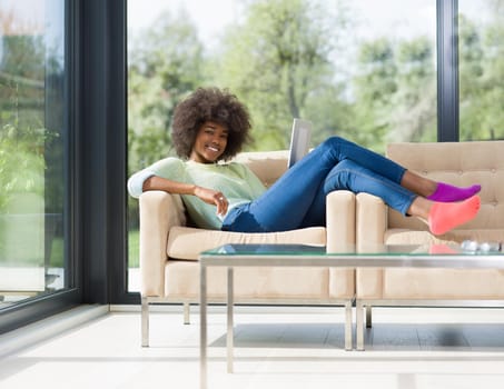 Young african american woman at home relaxing in her luxury lliving room reading a digital tablet  surf internet and work