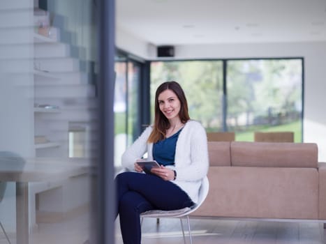 beautiful young women using tablet computer by the window  of her luxury home