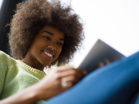 Young african american woman at home relaxing in her luxury lliving room reading a digital tablet  surf internet and work