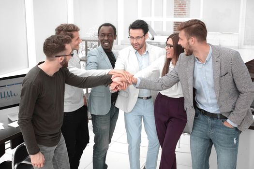 friendly business team putting their hands together . the concept of teamwork