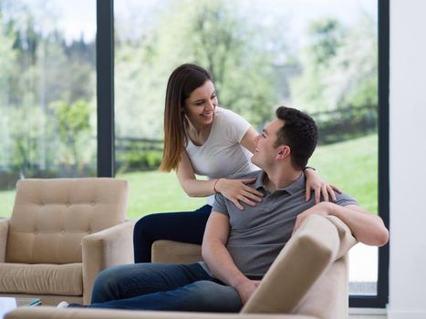 young handsome couple enjoys hugging on the sofa in their luxury home villa