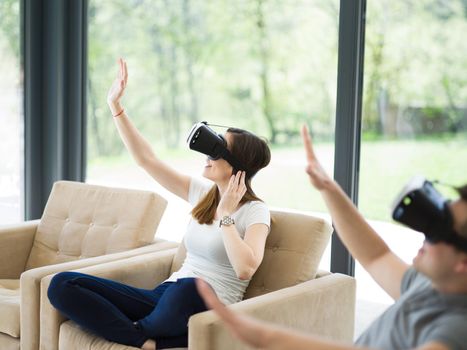 Couple using virtual reality headset in living room at home  people playing game with new trends technology