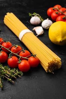 Spaghetti raw dry ingredients set, on black dark stone table background