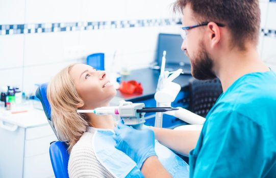 Dentist treating blond smiling girl